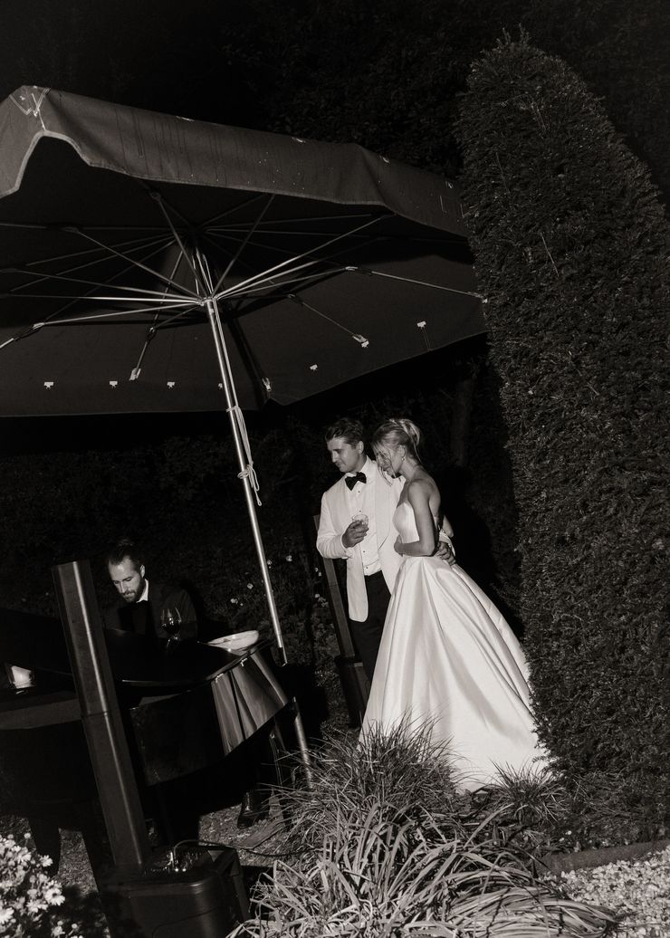 Arian M&uuml;ller playing piano at an evening garden wedding