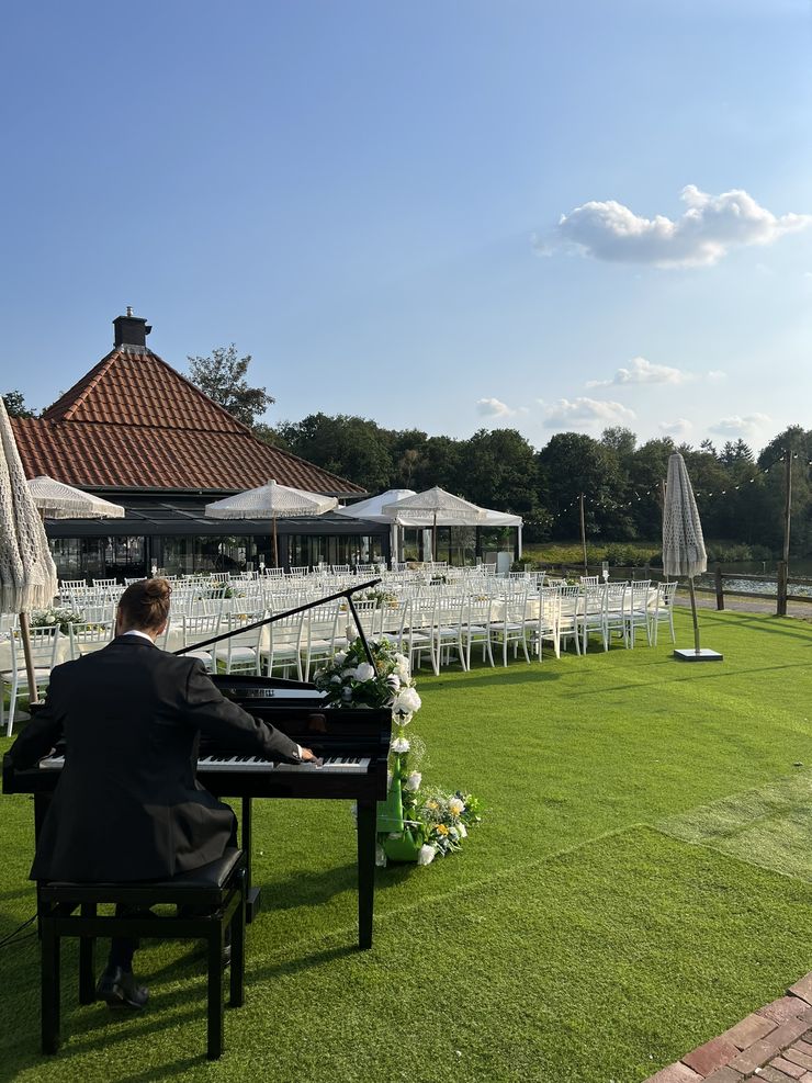 Arian M&uuml;ller playing at an outdoor lakeside wedding